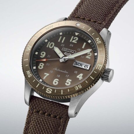 El Seiko 5 Sports Field Series HDB009 es un reloj diseñado para los amantes de la aventura y la exploración, combinando funcionalidad, resistencia y un auténtico estilo inspirado en el mundo outdoor. Su esfera en tono marrón tierra refleja los colores de la naturaleza y aporta una personalidad cálida y robusta al conjunto. Los números e indicadores recubiertos con LumiBrite garantizan una excelente legibilidad incluso en condiciones de poca luz, permitiendo consultar la hora de forma rápida y precisa en cualquier entorno. Para reforzar su carácter aventurero, este modelo incorpora una práctica brújula integrada, una función especialmente útil para actividades al aire libre. La resistente correa de nailon con detalles en cuero completa el diseño con una estética auténtica y cómoda, perfectamente alineada con el espíritu de la colección Field Series. La caja de acero inoxidable de 41 mm ofrece una presencia equilibrada y resistente, protegida por un cristal Hardlex curvado que aporta durabilidad y un atractivo aspecto clásico. Además, el fondo transparente atornillado permite admirar el movimiento mecánico en funcionamiento. En su interior late el reconocido calibre 4R36, un movimiento automático con capacidad de carga manual que proporciona aproximadamente 41 horas de reserva de marcha. También incorpora indicación de día y fecha y función de parada de segundero para un ajuste preciso de la hora. Con una resistencia al agua de 10 bares (100 metros), resistencia magnética de 4.800 A/m y bisel giratorio, el Seiko 5 Sports Field Series HDB009 está preparado para acompañarte tanto en la naturaleza como en el día a día, ofreciendo la fiabilidad y versatilidad que caracterizan a la colección 5 Sports. Referencia SEIKO: HDB009K1 Referencia interna: R-SEI-5SP-0023