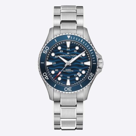 El Hamilton Khaki Navy Scuba Auto 40 mm H82425140 combina el espíritu aventurero de los relojes de buceo con un diseño contemporáneo pensado para acompañarte tanto dentro como fuera del agua. Esta nueva versión aporta una identidad más audaz a la colección gracias a su llamativa esfera azul lacada con textura ondulada, inspirada en el movimiento del océano, y a la renovada tipografía del bisel, que refuerza su carácter deportivo y moderno. Su caja de acero inoxidable de 40 mm ofrece un equilibrio perfecto entre presencia y comodidad, mientras que el cristal de zafiro con tratamiento antirreflejos garantiza una excelente resistencia y legibilidad. El robusto brazalete de acero inoxidable completa un conjunto versátil y elegante, ideal para el uso diario. Diseñado con el ADN de un auténtico reloj de buceo, incorpora bisel giratorio unidireccional de 60 minutos, corona roscada y una resistencia al agua de 100 metros (10 bares), características que aseguran fiabilidad y funcionalidad en cualquier entorno. En su interior late el calibre automático Hamilton H-10, un movimiento de alta precisión que ofrece una impresionante reserva de marcha de hasta 80 horas. Además, incorpora espiral Nivachron™, que mejora la resistencia a los campos magnéticos y contribuye a una mayor estabilidad y precisión del movimiento. Las agujas e índices con Super-LumiNova® garantizan una excelente visibilidad en condiciones de poca luz, reforzando su carácter deportivo y funcional. El Hamilton Khaki Navy Scuba Auto 40 mm es un reloj que une precisión suiza, resistencia y diseño contemporáneo, manteniendo vivo el legado de aventura y exploración que ha definido a Hamilton a lo largo de décadas de tradición en el mundo del buceo. Referencia Hamilton: H82425140 Referencia interna: R-HAM-KHA-0003