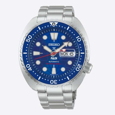 El Seiko Prospex Diver's Watch PADI 60th Anniversary Limited Edition SRPL53K1 (HBB002) celebra el 60.º aniversario de PADI y una década de colaboración entre ambas entidades, unidas por su compromiso con la seguridad en el buceo y la conservación de los océanos. Esta edición limitada a 8.000 unidades destaca por un diseño exclusivo inspirado en los colores del logotipo conmemorativo de PADI. Su llamativa esfera azul incorpora un sutil motivo de globo terráqueo, detalles en rojo en la aguja de los segundos y en el índice de las 6 horas, mientras que el bisel unidireccional con inserto de cerámica aporta una gran resistencia a los arañazos. La caja de acero inoxidable de 45 mm se complementa con un cristal de zafiro con lupa y tratamiento antirreflectante, así como con LumiBrite en agujas, índices y bisel para garantizar una excelente legibilidad bajo el agua. En su interior equipa el calibre automático 4R36, con capacidad de carga manual, 41 horas de reserva de marcha e indicación de día y fecha. Además del brazalete de acero inoxidable, esta edición especial incluye una correa adicional de silicona con diseño de acordeón, ideal para llevar sobre un traje de neopreno. En resumen, este Seiko Prospex PADI 60th Anniversary Limited Edition combina exclusividad, fiabilidad y prestaciones profesionales en un reloj de buceo diseñado para los apasionados del mar y la relojería. Descubre toda nuestra colección de los relojes Seiko Prospex. Referencia SEIKO: HBB002K1 Referencia interna: R-SEI-PRO-0005