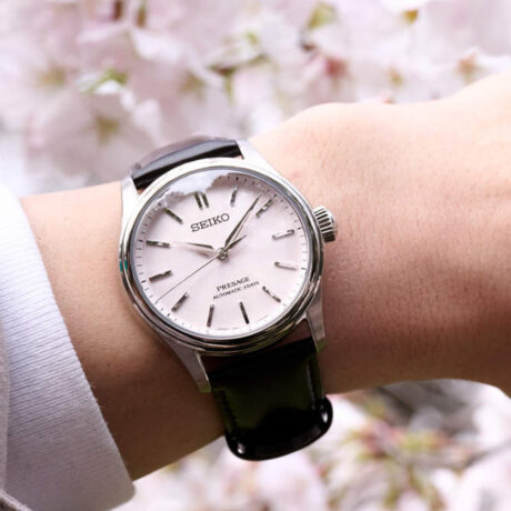 El Seiko Presage Classic Series Sakura Iro HCC003J1 captura la esencia de una de las estampas más emblemáticas de Japón a través de una elegante interpretación de los cerezos en flor. Su delicada esfera rosa sakura-iro evoca los suaves tonos de los pétalos de sakura, mientras que la correa de piel marrón oscuro, inspirada en el tronco del cerezo, aporta equilibrio y sofisticación al conjunto. En su interior incorpora el calibre automático 6R51, un movimiento mecánico de fabricación japonesa que ofrece una reserva de marcha de hasta 72 horas, garantizando precisión y fiabilidad durante varios días. Su diseño de tres agujas refleja la elegancia clásica característica de la colección Presage. La caja de acero inoxidable de 38 mm se combina con un cristal de zafiro de doble curvatura con tratamiento antirreflectante, que mejora la legibilidad y realza la belleza de la esfera. Además, cuenta con un fondo transparente roscado que permite admirar el movimiento automático, así como una resistencia al agua de 10 ATM (100 metros) para una mayor versatilidad en el uso diario. Referencia Seiko: HCC003J1 Referencia interna: R-SEI-PRE-0013