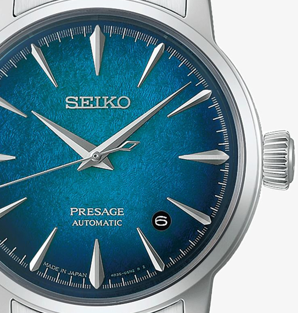 El Seiko Presage Cocktail Time Emerald Mist HCB001J1 destaca por una esfera de gran personalidad inspirada en la sofisticación de los cócteles japoneses. Sus profundos matices verde esmeralda con sutiles reflejos azulados crean un atractivo efecto de profundidad y luminosidad, mientras que el elaborado patrón de la esfera captura la luz desde distintos ángulos, aportando dinamismo y elegancia a cada movimiento. En su interior incorpora el calibre automático 4R35, un movimiento mecánico fiable y preciso que ofrece funciones de horas, minutos, segundos y calendario. La caja de acero inoxidable de 38,5 mm se combina con un elegante brazalete de acero, reforzando el carácter refinado de la colección Presage Cocktail Time. El reloj cuenta con un cristal Hardlex de forma abombada con tratamiento antirreflectante, que realza la profundidad visual de la esfera, y un fondo transparente roscado que permite admirar el movimiento automático. Su resistencia al agua de 5 bares (50 metros) lo convierte en una pieza versátil para el uso diario. En resumen, este Seiko Presage Cocktail Time Emerald Mist combina diseño sofisticado, acabados luminosos y precisión mecánica japonesa en un reloj elegante y contemporáneo. Referencia Seiko: HCB001J1 Referencia interna: R-SEI-PRE-0017