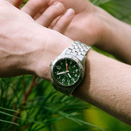 El Seiko 5 Sports Field GMT HDB001 reinterpreta el clásico reloj field con un diseño robusto, funcional y pensado para la aventura. Su esfera caqui aporta un marcado carácter utilitario y una excelente legibilidad, evocando los históricos relojes militares y de exploración. En su interior incorpora el calibre automático 4R34, con capacidad de carga manual, 24 rubíes y una reserva de marcha de aproximadamente 41 horas. Además de las funciones de horas, minutos y segundos, integra indicación de fecha y una práctica función GMT, que permite visualizar un segundo huso horario de un vistazo, ideal para viajes y uso diario. La caja de acero inoxidable de 39,4 mm se combina con un brazalete del mismo material y un cristal Hardlex curvado, aportando resistencia y un atractivo toque vintage. El reloj cuenta también con LumiBrite en agujas e índices para facilitar la lectura en condiciones de poca luz, así como con un fondo transparente roscado que permite admirar el movimiento automático. Con una resistencia al agua de 10 bares (100 metros) y cierre de seguridad de tres pliegues con pulsador, este modelo ofrece la fiabilidad y versatilidad características de la colección Seiko 5 Sports. En resumen, el Seiko 5 Sports Field GMT HDB001 combina estética field, funcionalidad GMT y robustez mecánica en un reloj deportivo y versátil preparado para cualquier aventura. Referencia Seiko: HDB001K1 Referencia interna: R-SEI-5SP-0024
