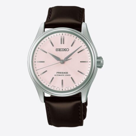 El Seiko Presage Classic Series Sakura Iro HCC003J1 captura la esencia de una de las estampas más emblemáticas de Japón a través de una elegante interpretación de los cerezos en flor. Su delicada esfera rosa sakura-iro evoca los suaves tonos de los pétalos de sakura, mientras que la correa de piel marrón oscuro, inspirada en el tronco del cerezo, aporta equilibrio y sofisticación al conjunto. En su interior incorpora el calibre automático 6R51, un movimiento mecánico de fabricación japonesa que ofrece una reserva de marcha de hasta 72 horas, garantizando precisión y fiabilidad durante varios días. Su diseño de tres agujas refleja la elegancia clásica característica de la colección Presage. La caja de acero inoxidable de 38 mm se combina con un cristal de zafiro de doble curvatura con tratamiento antirreflectante, que mejora la legibilidad y realza la belleza de la esfera. Además, cuenta con un fondo transparente roscado que permite admirar el movimiento automático, así como una resistencia al agua de 10 ATM (100 metros) para una mayor versatilidad en el uso diario. Referencia Seiko: HCC003J1 Referencia interna: R-SEI-PRE-0013