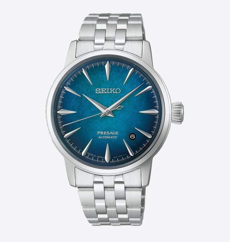El Seiko Presage Cocktail Time Emerald Mist HCB001J1 destaca por una esfera de gran personalidad inspirada en la sofisticación de los cócteles japoneses. Sus profundos matices verde esmeralda con sutiles reflejos azulados crean un atractivo efecto de profundidad y luminosidad, mientras que el elaborado patrón de la esfera captura la luz desde distintos ángulos, aportando dinamismo y elegancia a cada movimiento. En su interior incorpora el calibre automático 4R35, un movimiento mecánico fiable y preciso que ofrece funciones de horas, minutos, segundos y calendario. La caja de acero inoxidable de 38,5 mm se combina con un elegante brazalete de acero, reforzando el carácter refinado de la colección Presage Cocktail Time. El reloj cuenta con un cristal Hardlex de forma abombada con tratamiento antirreflectante, que realza la profundidad visual de la esfera, y un fondo transparente roscado que permite admirar el movimiento automático. Su resistencia al agua de 5 bares (50 metros) lo convierte en una pieza versátil para el uso diario. En resumen, este Seiko Presage Cocktail Time Emerald Mist combina diseño sofisticado, acabados luminosos y precisión mecánica japonesa en un reloj elegante y contemporáneo. Referencia Seiko: HCB001J1 Referencia interna: R-SEI-PRE-0017