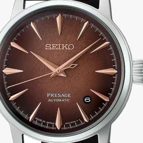 El Seiko Presage Cocktail Time Whiskey Mist HCB003J1 destaca por su elegante esfera en tonos ámbar, cobre y marrón, inspirada en la calidez y profundidad de los destilados envejecidos. Su acabado texturizado y sus reflejos cambiantes crean un atractivo efecto visual que aporta profundidad y personalidad al conjunto. La correa de piel de vacuno en marrón oscuro completa su estética clásica y refinada. En su interior incorpora el calibre automático 4R35, con capacidad de carga manual, una reserva de marcha aproximada de 41 horas y 23 rubíes. Además, cuenta con función de parada del segundero y visualización de la fecha, ofreciendo una lectura práctica para el día a día. La caja de acero inoxidable de 38,5 mm incorpora un cristal Hardlex en forma de caja y tratamiento antirreflectante. Las agujas e índices permiten una lectura clara, mientras que la correa de piel de vacuno marrón se integra con un cierre de tres pliegues con botón de apertura. El fondo de caja transparente y de rosca permite apreciar el movimiento mecánico en su interior. Con una resistencia al agua de 5 bares y resistencia magnética de 4.800 A/m, el Seiko Presage Cocktail Time Whiskey Mist HCB003J1 combina la tradición de la relojería mecánica con una estética sofisticada inspirada en el universo de la coctelería. Referencia Seiko: HCB003J1 Referencia interna: R-SEI-PRE-0019