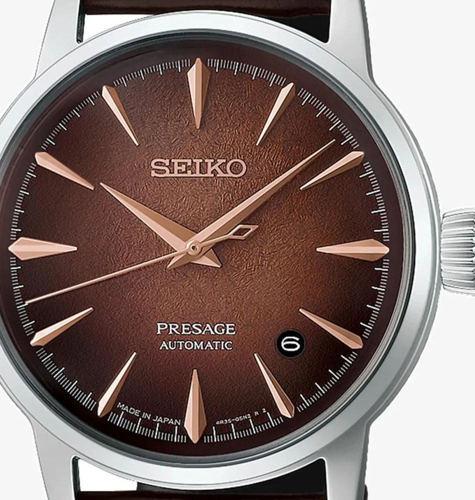 El Seiko Presage Cocktail Time Whiskey Mist HCB003J1 destaca por su elegante esfera en tonos ámbar, cobre y marrón, inspirada en la calidez y profundidad de los destilados envejecidos. Su acabado texturizado y sus reflejos cambiantes crean un atractivo efecto visual que aporta profundidad y personalidad al conjunto. La correa de piel de vacuno en marrón oscuro completa su estética clásica y refinada. En su interior incorpora el calibre automático 4R35, con capacidad de carga manual, una reserva de marcha aproximada de 41 horas y 23 rubíes. Además, cuenta con función de parada del segundero y visualización de la fecha, ofreciendo una lectura práctica para el día a día. La caja de acero inoxidable de 38,5 mm incorpora un cristal Hardlex en forma de caja y tratamiento antirreflectante. Las agujas e índices permiten una lectura clara, mientras que la correa de piel de vacuno marrón se integra con un cierre de tres pliegues con botón de apertura. El fondo de caja transparente y de rosca permite apreciar el movimiento mecánico en su interior. Con una resistencia al agua de 5 bares y resistencia magnética de 4.800 A/m, el Seiko Presage Cocktail Time Whiskey Mist HCB003J1 combina la tradición de la relojería mecánica con una estética sofisticada inspirada en el universo de la coctelería. Referencia Seiko: HCB003J1 Referencia interna: R-SEI-PRE-0019